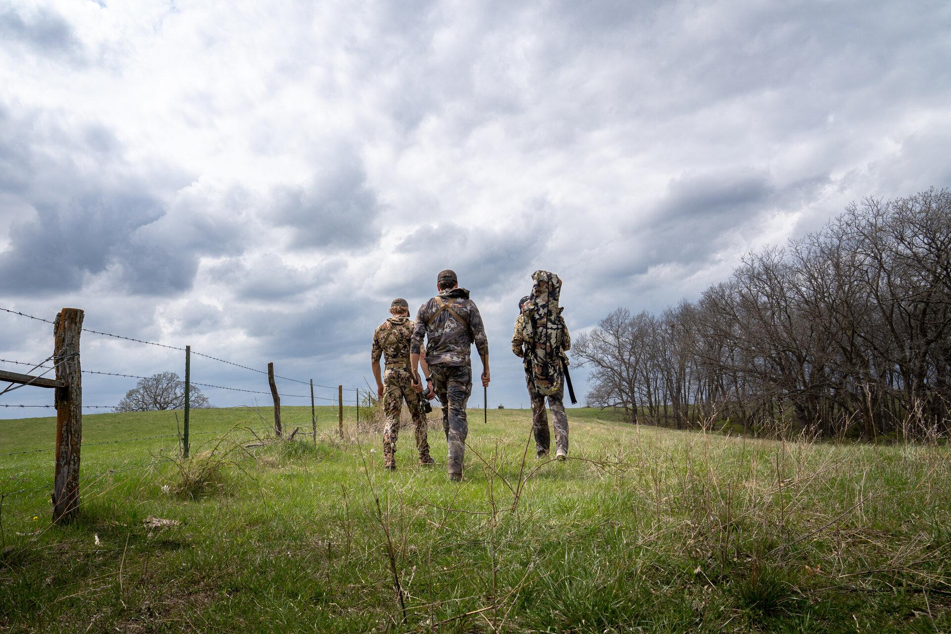 Hunters walking across a field on leased land